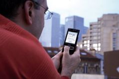 Personne accédant à internet dans la rue à l'aide de son mobile