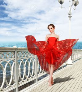 14209990-sexy-young-woman-in-long-red-dress-flying-under-wi