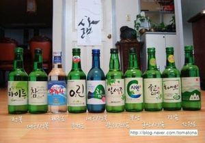 Mand Hand Verse De L'alcool Coréen Soju Dans Le Verre Sloki