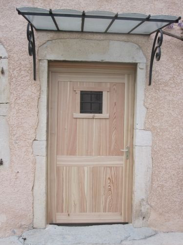 Porte entrée en mélèze massif, bois sélectionnés, serrure 3 points, fabrication artisanale Menuiserie Le Bois Des Huile Porte-entree-rustique-en-meleze--linteau-pierre--grille-.jpg