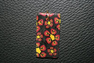 pendentif rectangulaire avec fleurs rouge noir et jaune