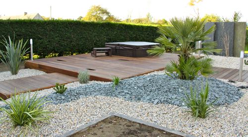 aménagement minéral de jardin entre jacuzzi et terrasse en bois à vannes