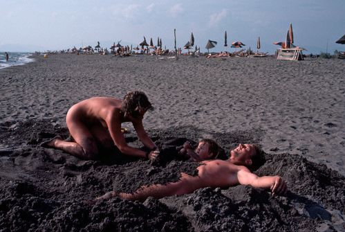 Happy Family Nudism Playing And Relaxing In Beach