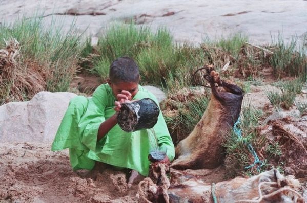 Un-enfant-targui-en-train-de-remplir-de-l-eau-dans-sa-guerb.jpg