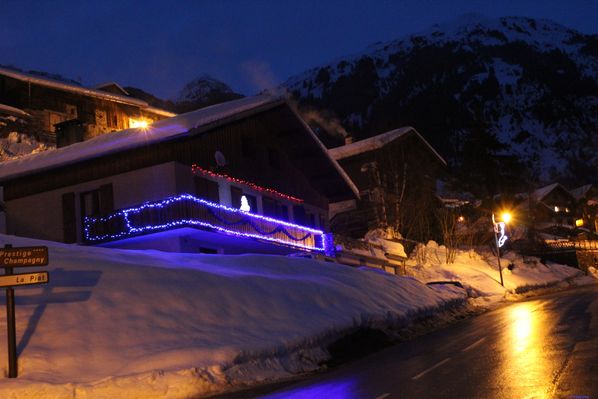 chalet illuminé sous la neige