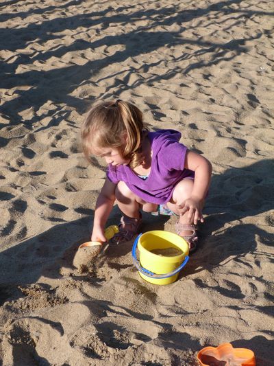 petite fille joue avec le sable