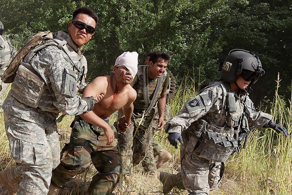 Army soldiers helped a wounded Afghan